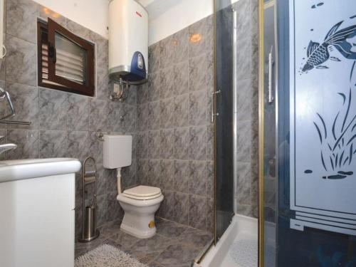 a bathroom with a toilet and a glass shower at Villa Blanka in Podgora