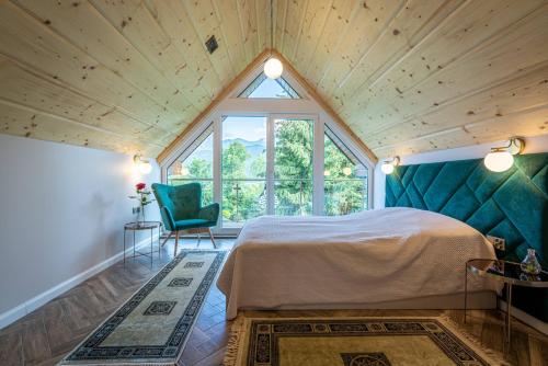 a bedroom with a bed and a large window at Widokowy Domek Jaś i Małgosia in Kościelisko