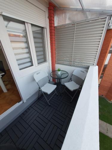ein Balkon mit zwei Stühlen und einem Tisch in der Unterkunft Apartment Pallaton in Našice