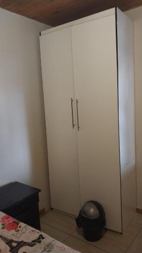 a bedroom with a large white cabinet next to a bed at Jay's Guest House in Witbank