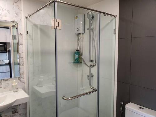 a shower with a glass door in a bathroom at Chinatown Watmungkorn MRT Yaowaraj Bangkok in Bangkok