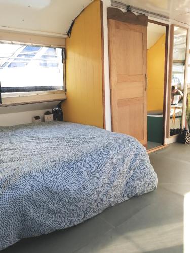 a bedroom with a bed and a window and a door at Esprit Péniche in Nantes