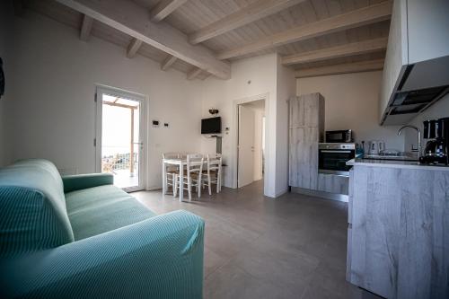 a living room with a green couch and a kitchen at Sunrise in Cipressa