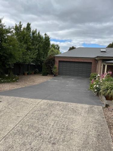 a driveway in front of a house with a garage at Quiet family retreat getaway - Wildlife Park, Sovereign Hill, Kryall Castle and city at your door - modern house, 8 guests, 4 bedrooms, 5 beds in Ballarat
