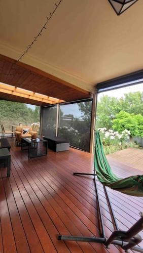 a living room with a hammock on a wooden deck at Quiet family retreat getaway - Wildlife Park, Sovereign Hill, Kryall Castle and city at your door - modern house, 8 guests, 4 bedrooms, 5 beds in Ballarat
