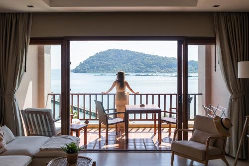 象島的住宿－Tina Holiday Homes，站在一个眺望海洋的阳台上的女人