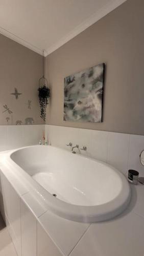 a white bath tub in a white bathroom at Quiet family retreat getaway - Wildlife Park, Sovereign Hill, Kryall Castle and city at your door - modern house, 8 guests, 4 bedrooms, 5 beds in Ballarat