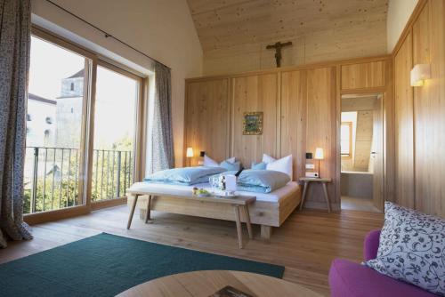 ein Schlafzimmer mit einem Bett und einem großen Fenster in der Unterkunft Romantik Hotel Zum Klosterbräu in Neuburg an der Donau