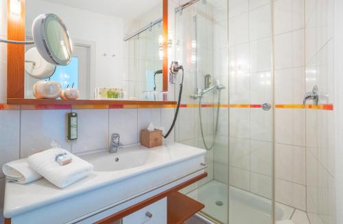 a bathroom with a sink and a shower at Hotel Fährhaus in Norddeich