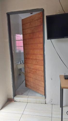 a wooden door in a room with a sink at Jay's Guest House in Witbank