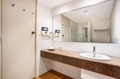 a bathroom with a sink and a mirror at Richmond Henty Hotel in Portland