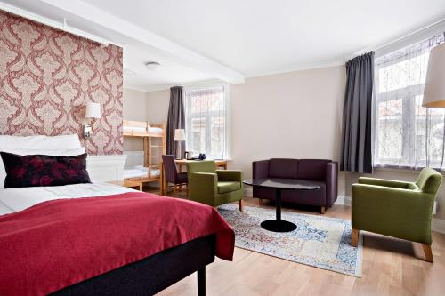Best Western Plus Hotel Bakeriet في تروندهايم: غرفة نوم بسرير وكراسي ومكتب