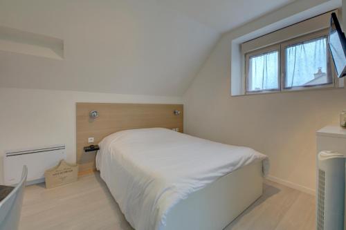 sypialnia z białym łóżkiem i oknem w obiekcie La petite maison 3 w mieście Avoine