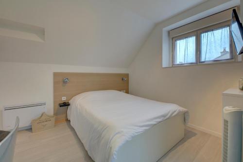 a bedroom with a white bed and a window at La petite maison 3 in Avoine
