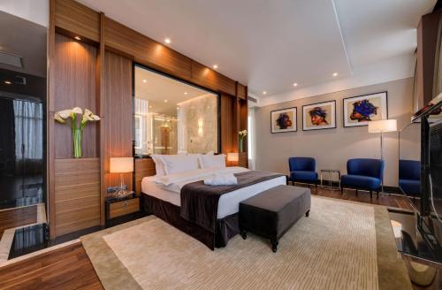 - une chambre avec un lit et deux chaises bleues dans l'établissement Radisson Blu Leogrand Hotel, à Chişinău