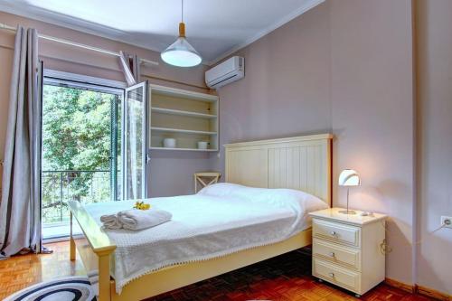 a bedroom with a white bed and a window at Kellys Apartment in Anemómylos
