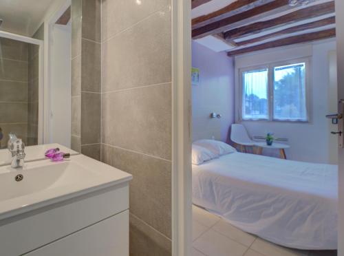 a bathroom with a bed and a shower and a sink at La petite maison 4 in Avoine