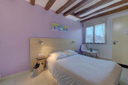 a bedroom with a white bed and a window at La petite maison 4 in Avoine