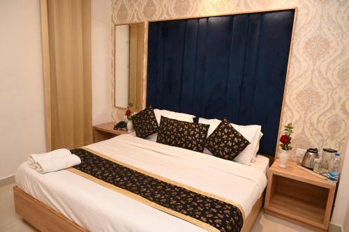 a bedroom with a large bed with a blue headboard at Hotel Diamond Villa l Hotel Near Golden Temple Amritsar l Hotel In Amritsar l Best Hotel In Amritsar in Amritsar