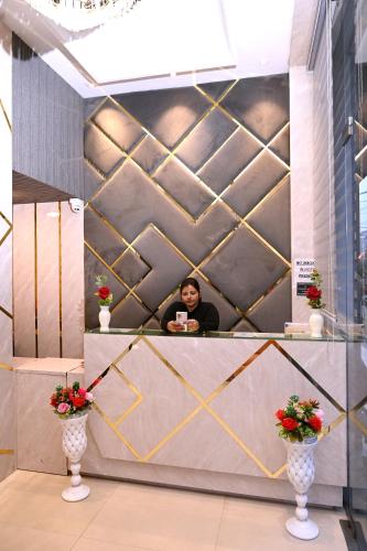 a man sitting at a counter with a cup of coffee at Hotel Diamond Villa l Hotel Near Golden Temple Amritsar l Hotel In Amritsar l Best Hotel In Amritsar in Amritsar