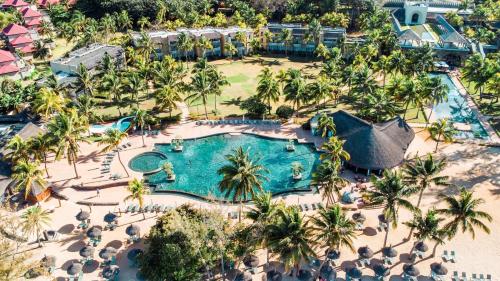 una vista aérea de una piscina del complejo con palmeras en Outrigger Mauritius Beach Resort, en Bel Ombre