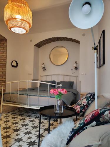 Un dormitorio con una cama y una mesa con flores. en Studio apartment Frano en Zagreb