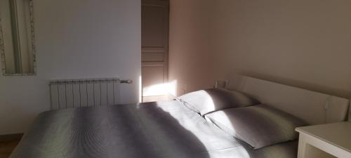 a bedroom with a bed in a white room at La Halte Gourmande in Vachères
