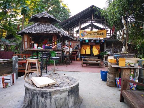 a store with a tree stump in front of it at Pai River Jam Hostel & Campground in Pai