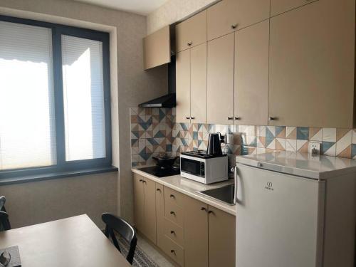 a kitchen with a white refrigerator and a microwave at Tashkent City View Apart in Tashkent