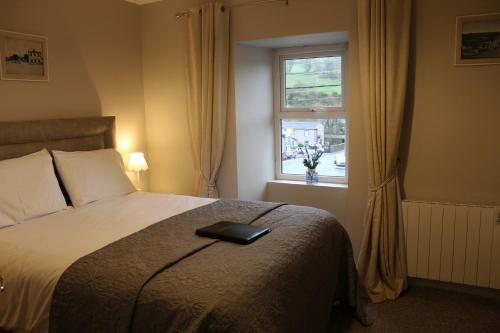 a bedroom with a bed with a black book on it at Madelines Accommodation in Tinahely