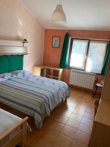 a bedroom with two beds and a window at Rita’s Loft in Castelpetroso