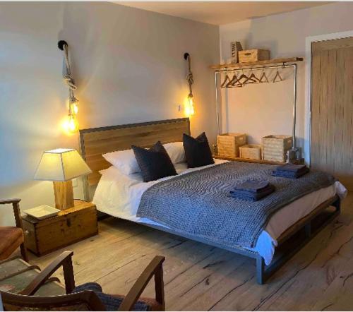 a bedroom with a large bed and a chair at Fig Tree House in Lymington