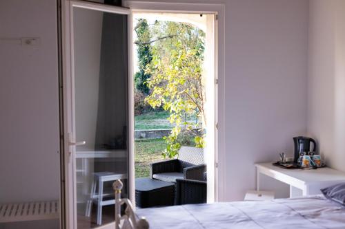 a bedroom with a door open to a patio at La Halte Gourmande in Vachères