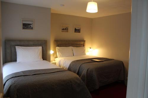 a hotel room with two beds and two lamps at Madelines Accommodation in Tinahely