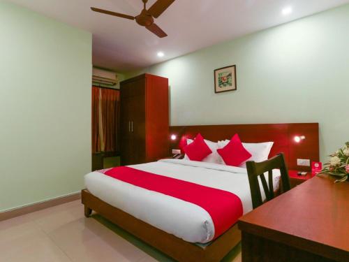 um quarto com uma cama grande e almofadas vermelhas em HOTEL NEWCASTLE em Vadakkāncheri