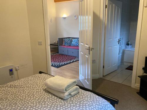 a bedroom with a bed with towels on top of it at CV225AA 1 Bedroom-Near Rugby School-Ground Floor-WiFi-Self Check In in Rugby