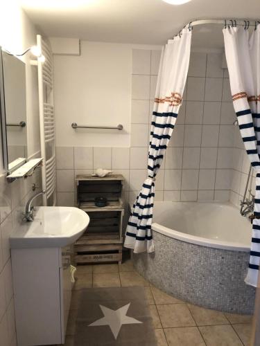 a bathroom with a bath tub and a sink at Ferienhof Sandmann in Wangels