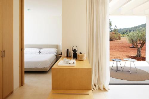 a bedroom with a bed and a large window at Ca Na Xica - Hotel & Spa in Sant Miquel de Balansat