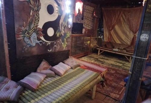 una camera con un letto e un dipinto sul muro di Pai River Jam Hostel & Campground a Pai