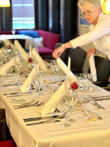 a man is standing at a long table with wine glasses at relexa hotel Schatten Stuttgart in Stuttgart