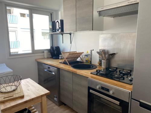 une cuisine avec une cuisinière et un comptoir dans l'établissement Confort - Appartement Cosy - Proche Mer ***, à Vallauris