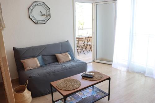 un salon avec un canapé et une table dans l'établissement Confort - Appartement Cosy - Proche Mer ***, à Vallauris