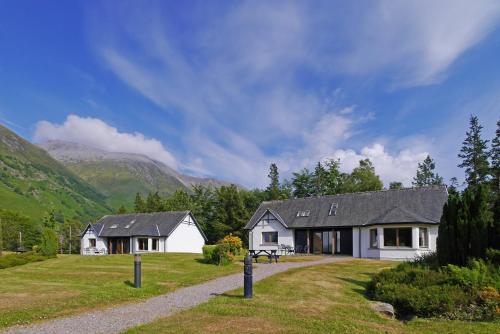 una casa blanca en medio de un campo en Glen Nevis Holidays, en Fort William