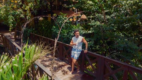 a man standing on a wooden bridge at ThalassaGarden Hotel - Pousada in Pipa
