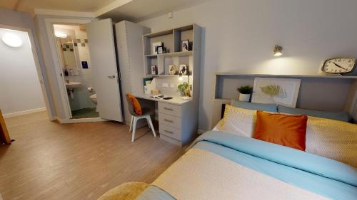 een slaapkamer met een bed, een bureau en een wastafel bij Comfy Ensuite Bedrooms at Manchester Gardens near City Centre in Manchester