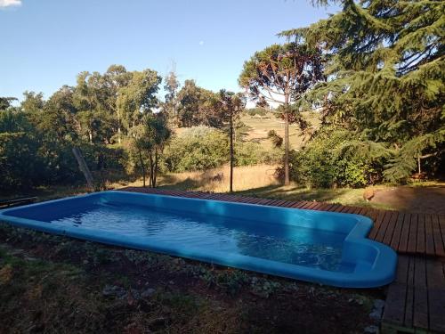 una piscina rectangular azul en el patio en Posada A Viagem en Tandil