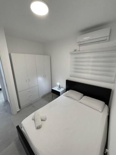 a bedroom with a white bed and a white ceiling at Apartment Bliss in Bat Yam