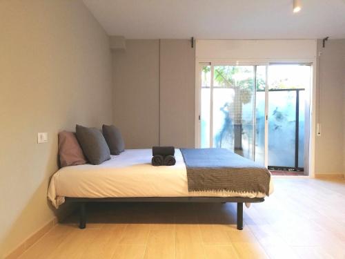 um quarto com uma cama grande e uma janela grande em Mazi Apartments Suite em Mataró