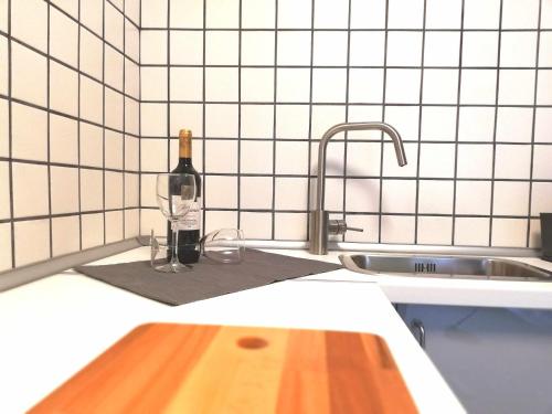 uma garrafa de vinho sentada ao lado de um lavatório de cozinha em Mazi Apartments Suite em Mataró