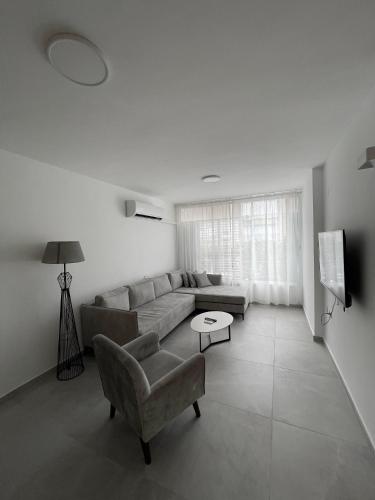 a living room with a couch and a chair at Apartment Bliss in Bat Yam